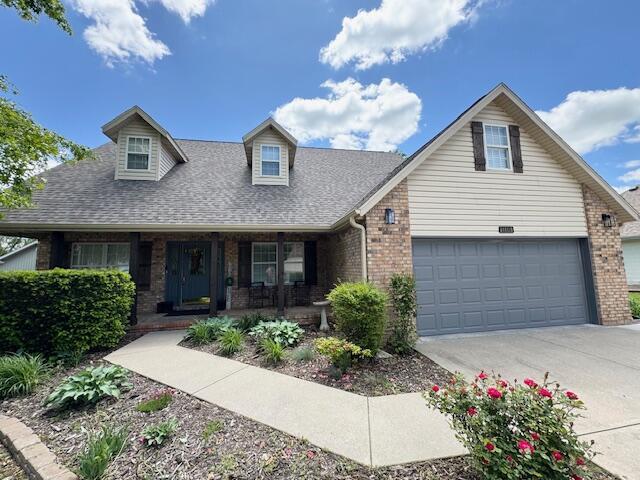 1118 E Ritter St, Republic, MO 65738 - cape cod home with driveway, roof with shingles, brick siding, and covered porch