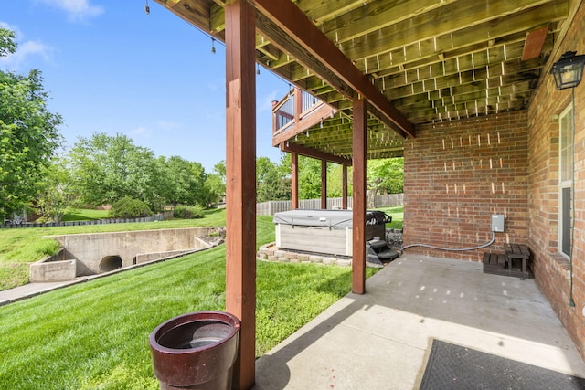 view of patio / terrace featuring a hot tub and fence