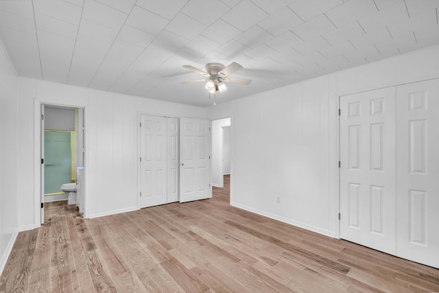 unfurnished bedroom with baseboards, light wood finished floors, and connected bathroom