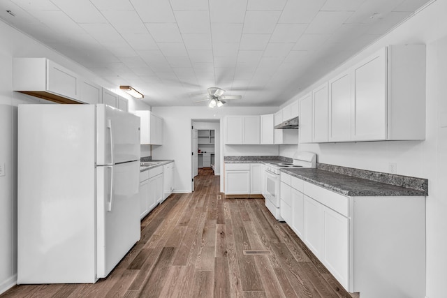 kitchen featuring a ceiling fan, dark countertops, dark wood-type flooring, white appliances, and under cabinet range hood