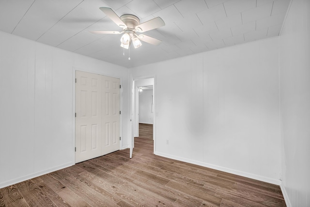 unfurnished bedroom featuring baseboards, ceiling fan, and wood finished floors