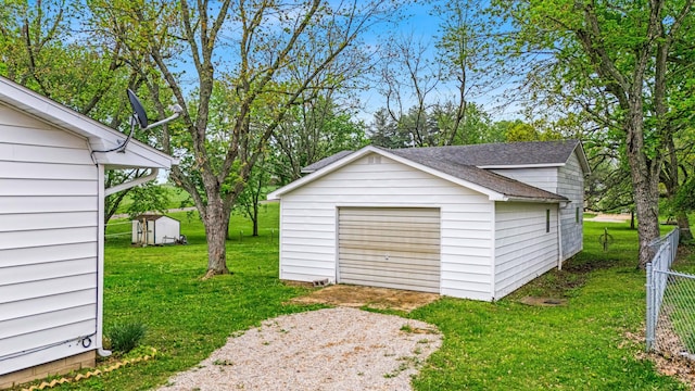 detached garage with fence and driveway