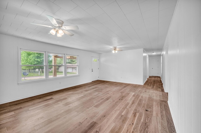 unfurnished living room featuring light wood-type flooring, baseboards, and ceiling fan