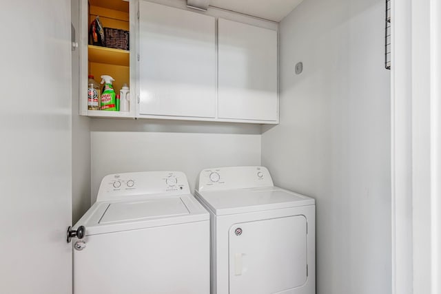 washroom with separate washer and dryer and cabinet space