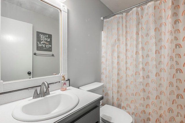 bathroom featuring toilet, vanity, and a shower with shower curtain