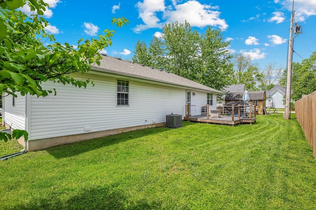 rear view of house with a yard, a deck, central air condition unit, and fence
