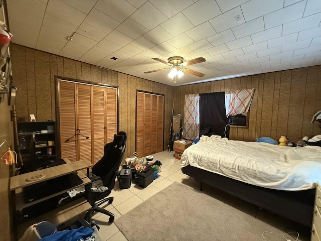 1398 County Road 670, Birch Tree, MO 65438 - bedroom featuring two closets, light tile patterned floors, wood walls, and ceiling fan