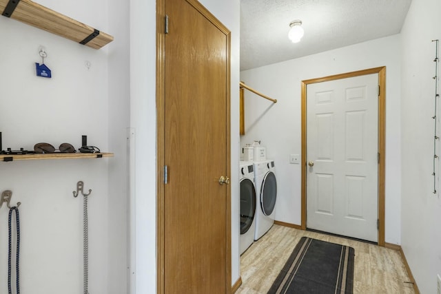 washroom with laundry area, light wood-style flooring, baseboards, and independent washer and dryer