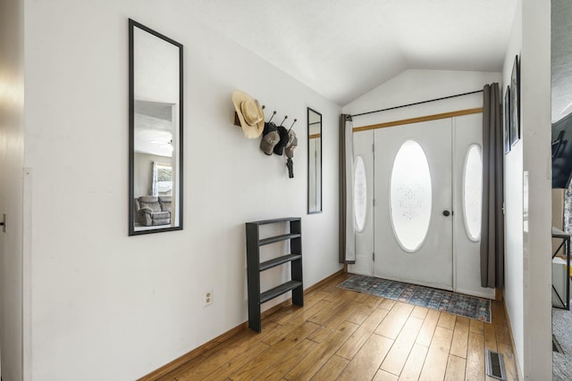 entryway featuring visible vents, wood finished floors, and lofted ceiling