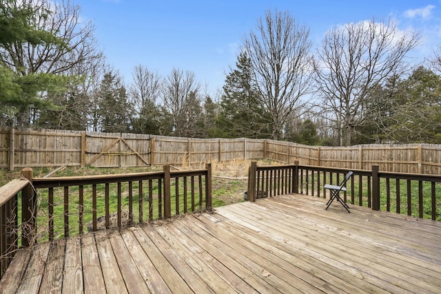 wooden deck with a fenced backyard
