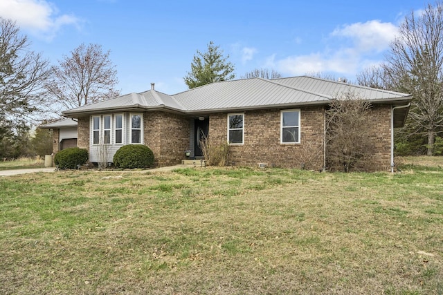 ranch-style home featuring metal roof, brick siding, a front lawn, and an attached garage