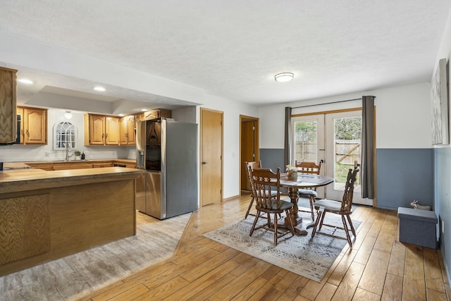 interior space featuring light wood-style flooring, a textured ceiling, and recessed lighting