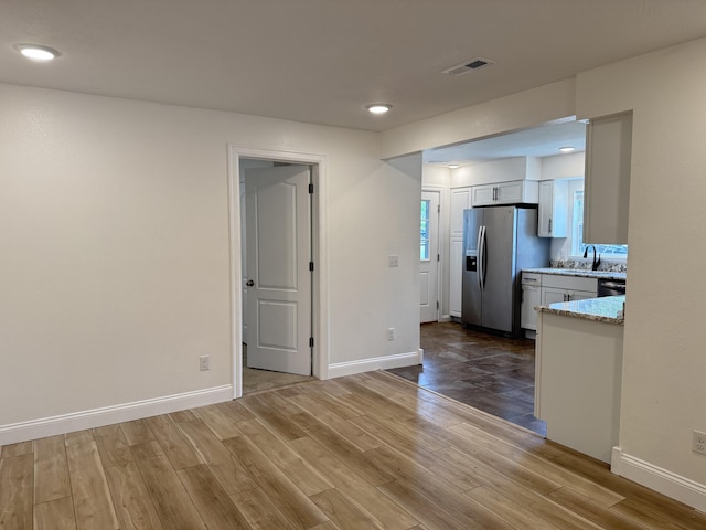 interior space with recessed lighting, baseboards, visible vents, a sink, and wood finished floors