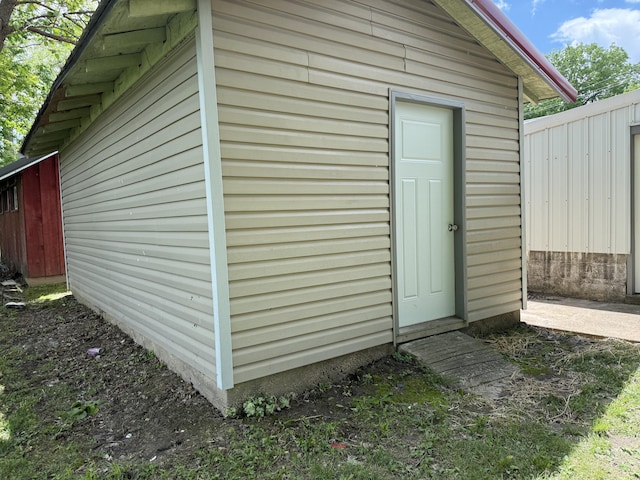 view of outdoor structure featuring fence and an outbuilding