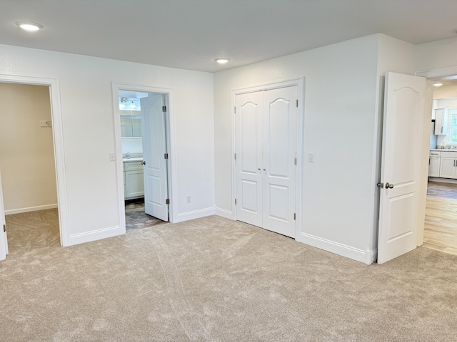 unfurnished bedroom featuring a closet, baseboards, and carpet