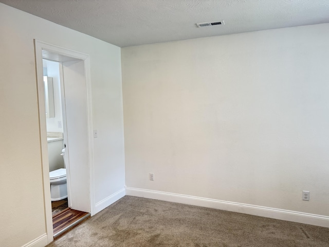 carpeted spare room with baseboards and visible vents
