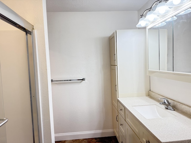 bathroom with a shower with shower door and vanity