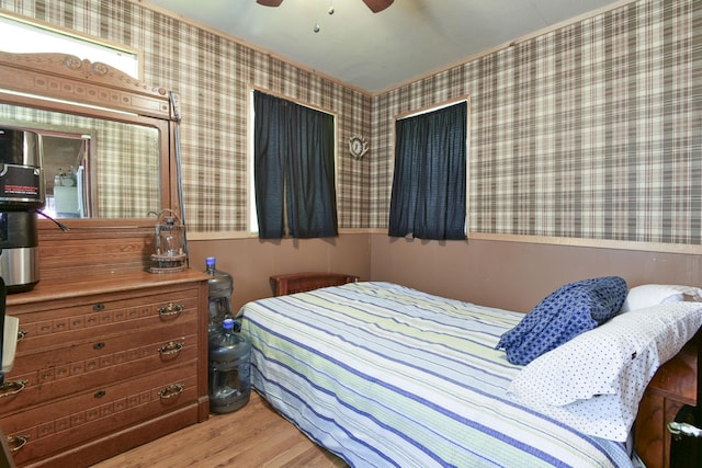 bedroom featuring wallpapered walls, wood finished floors, and ceiling fan