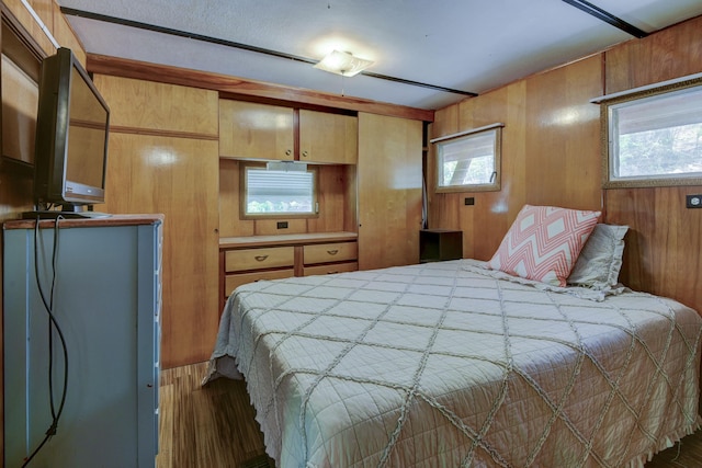 bedroom featuring wooden walls and wood finished floors