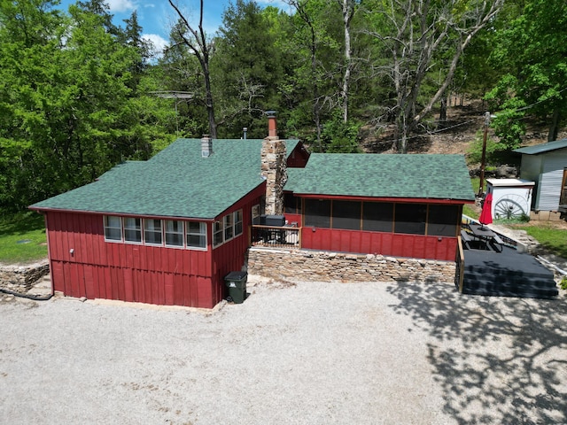 view of front of home featuring a chimney and roof with shingles