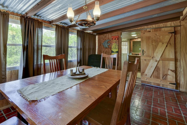 dining room with a chandelier, brick floor, and wooden walls