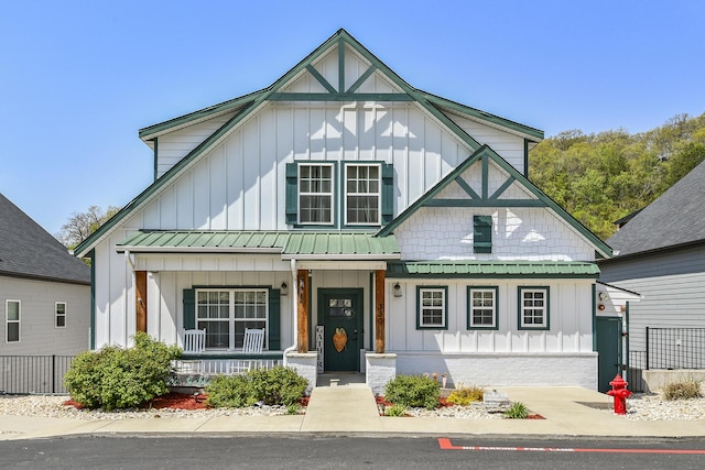 view of front facade featuring covered porch, a standing seam roof, and board and batten siding