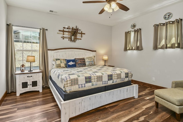 bedroom with baseboards, ceiling fan, visible vents, and wood finished floors