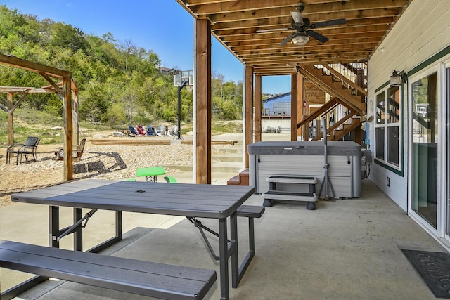 view of patio with stairs, a hot tub, and ceiling fan