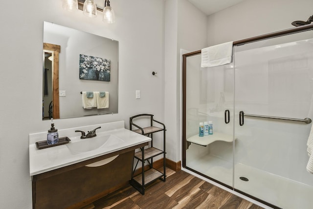 bathroom featuring vanity, a shower stall, and wood finished floors