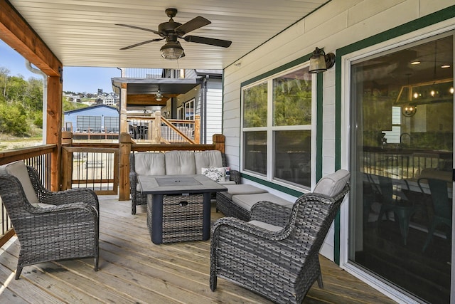 deck with an outdoor living space with a fire pit and a ceiling fan
