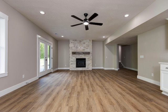 385 Plumtree Dr, Ozark, MO 65721 - unfurnished living room featuring stairway, light wood-style flooring, a ceiling fan, baseboards, and a stone fireplace