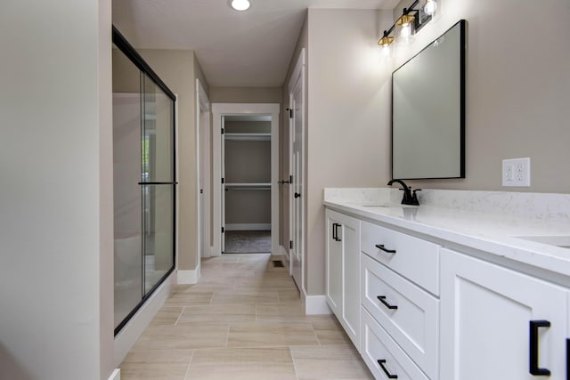 385 Plumtree Dr, Ozark, MO 65721 - full bathroom featuring a stall shower, double vanity, a sink, and a walk in closet