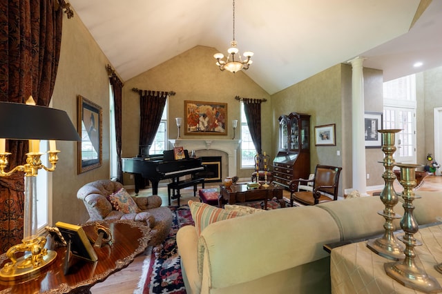 living room featuring an inviting chandelier, wood finished floors, a fireplace, and high vaulted ceiling