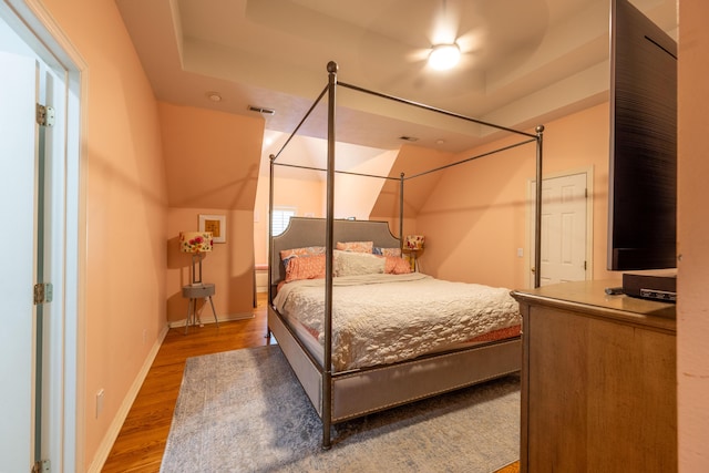 bedroom featuring baseboards, visible vents, and wood finished floors
