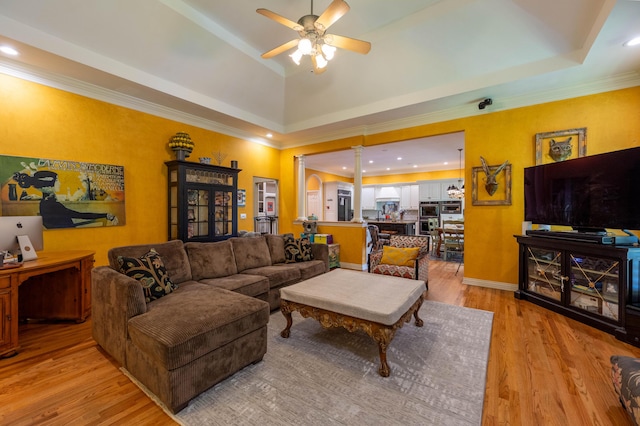 living room with light wood-type flooring, a raised ceiling, a ceiling fan, and recessed lighting