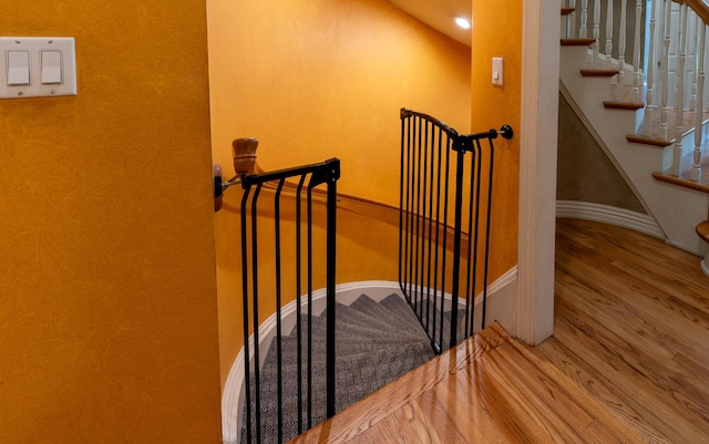 stairs with wood finished floors and baseboards