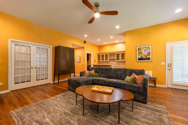 living room featuring a ceiling fan, baseboards, and wood finished floors