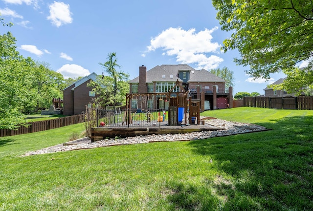 exterior space with a playground, a lawn, and a fenced backyard