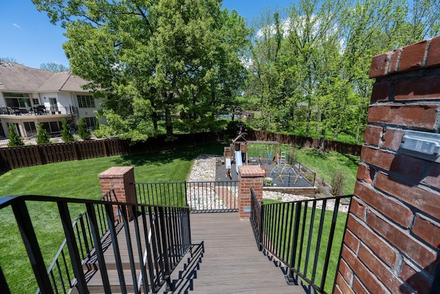 wooden terrace with a fenced backyard, a garden, and a lawn