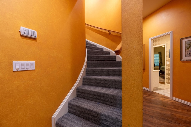 staircase with baseboards and wood finished floors