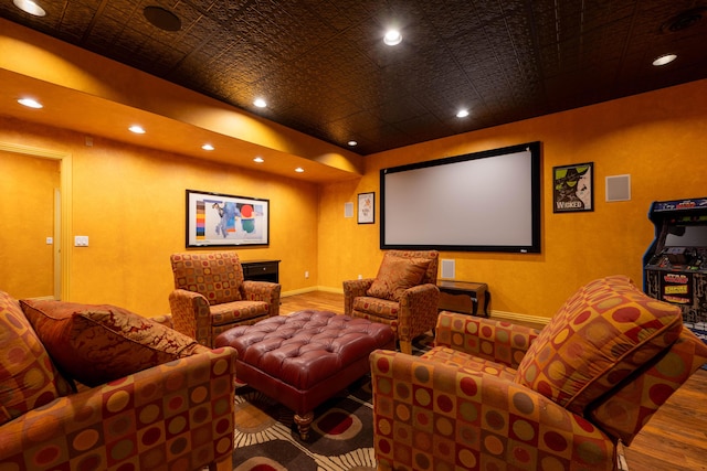 home theater room featuring wood finished floors, an ornate ceiling, and recessed lighting