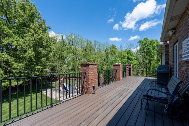 wooden deck with a lawn and grilling area