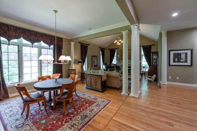 dining area with crown molding, light wood-style floors, ornate columns, and a notable chandelier