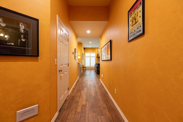 hallway with recessed lighting, baseboards, visible vents, and wood finished floors