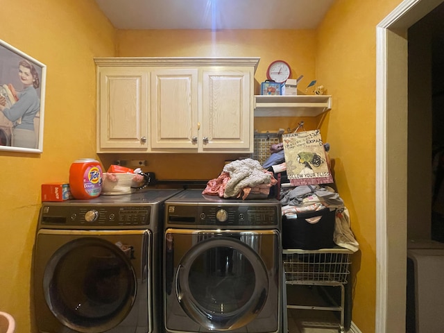 washroom with cabinet space and washer and clothes dryer