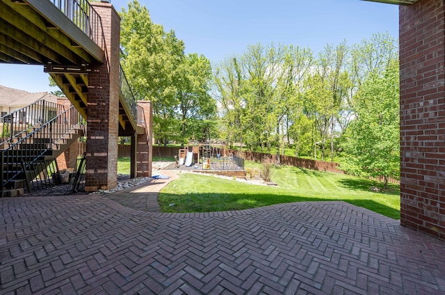 view of patio / terrace featuring a fenced backyard, stairs, and a playground