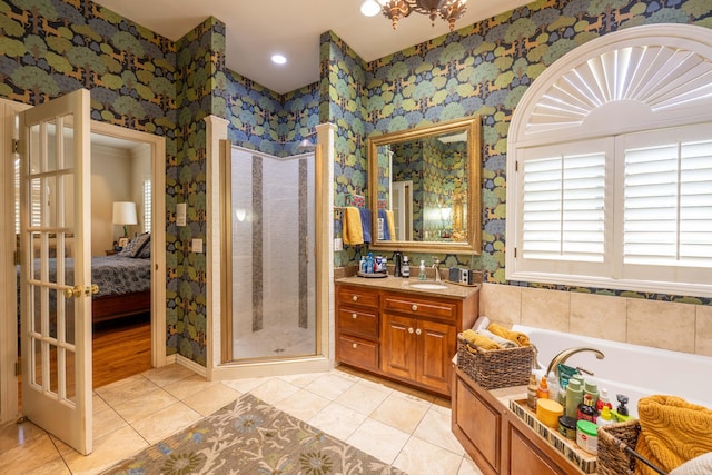 bathroom with a garden tub, tile patterned floors, ensuite bathroom, a shower stall, and vanity