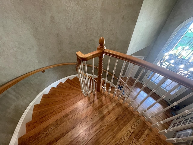 stairs with a high ceiling and wood finished floors