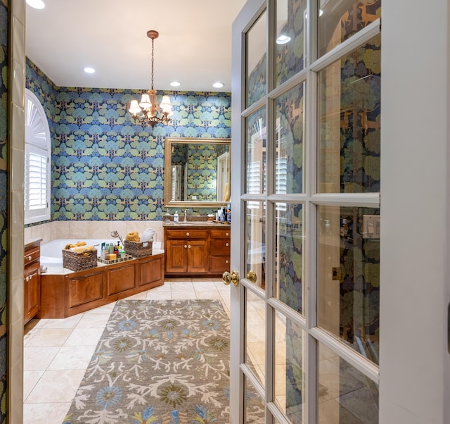 full bath featuring vanity, tile patterned floors, a chandelier, a bath, and wallpapered walls