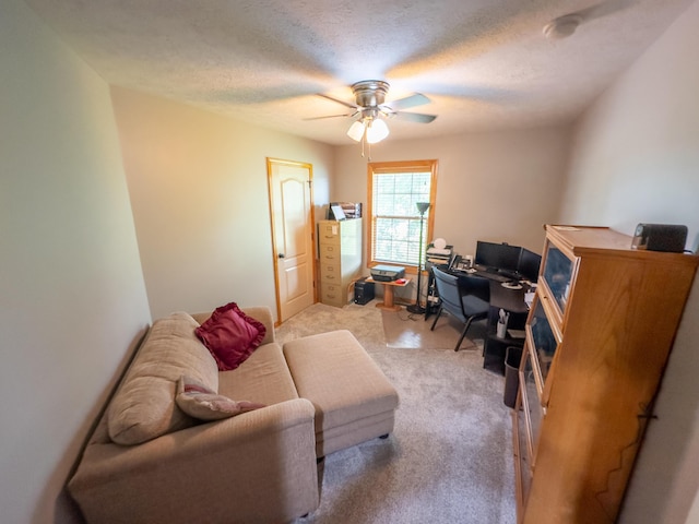 carpeted home office with a textured ceiling and a ceiling fan
